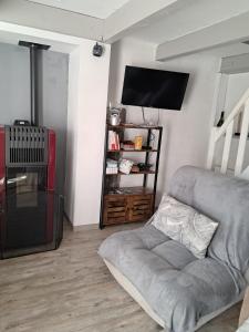 a living room with a couch and a flat screen tv at La Modestine in Lanuéjols