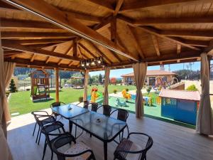 a patio with a table and chairs and a playground at Perla Guest House in Dospat