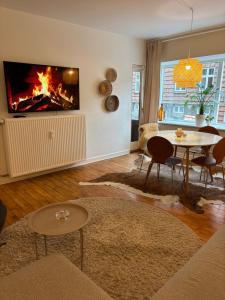 a living room with a table and a fire in the wall at Vejle Liv in Vejle