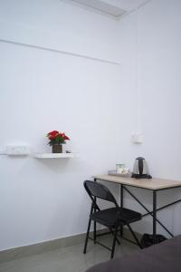 a desk with a chair next to a white wall at Shivalik stays in Jorhat