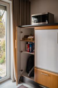 a cabinet with a microwave on top of it next to a window at Helle Wohnung in Seenähe in Berg am Starnberger See