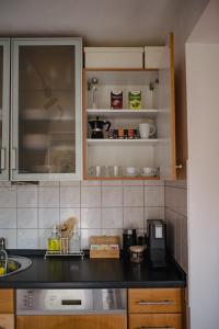 a kitchen with a black counter top and cabinets at Helle Wohnung in Seenähe in Berg am Starnberger See