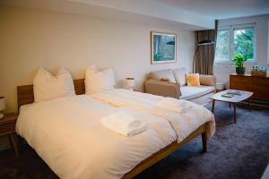 a bedroom with a large white bed and a couch at Helle Wohnung in Seenähe in Berg am Starnberger See +12 photos