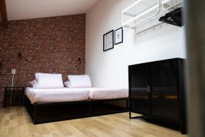 a bed in a room with a brick wall at Yart in Scharendijke