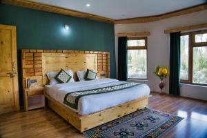 a bedroom with a large bed and a green wall at Semba retreat in Hundar