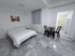 a bedroom with a bed and a table and chairs at Urban garden loft 3 in Haifa