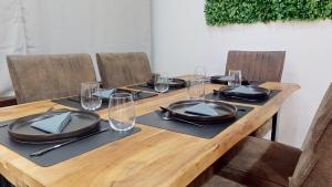 a wooden table with chairs and plates and glasses at Wohnung mit Heimkino mitten in der Altstadt in Celle