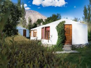 a small white building with a wooden door at Semba retreat in Hundar