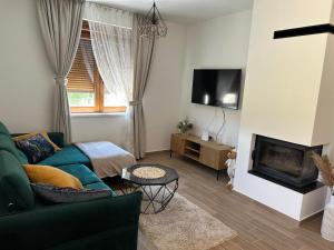 a living room with a couch and a fireplace at Villa BELEVITA odmor u prirodi sa grijanim bazenom in Čepelovac