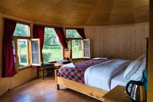 a bedroom with a bed in a room with windows at Semba retreat in Hundar +29 photos