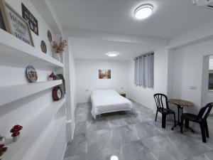 a bedroom with a bed and a table and chairs at Urban garden loft 3 in Haifa