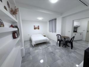 a bedroom with a bed and a table and chairs at Urban garden loft 3 in Haifa