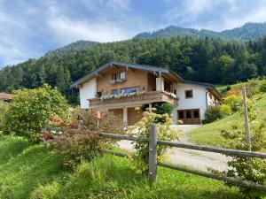 a house on a hill with a fence at Staller Hof inkl. Chiemgaukarte in Ruhpolding