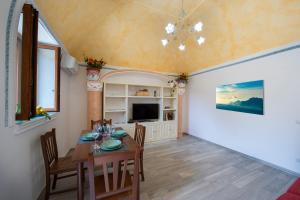 a dining room with a table and a tv at Casa Sery in Positano