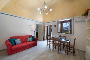 a living room with a red couch and a table at Casa Sery in Positano +23 photos