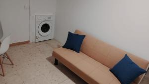 a couch with two blue pillows in a living room at Atico Marin playa in Marín