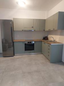 a kitchen with gray cabinets and a refrigerator at Puerto Serifos in Livadi