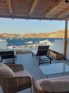a balcony with chairs and a view of a marina at Puerto Serifos in Livadi