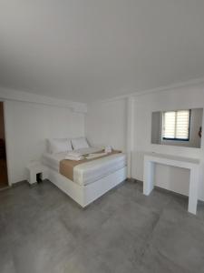 a white room with a bed and a mirror at Puerto Serifos in Livadi