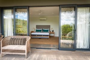 a bedroom with a bed and sliding glass doors at Sungulwane Private Game Lodge in Hluhluwe +68 photos