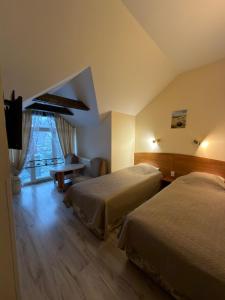 a hotel room with two beds and a television at Morena in Klaipėda