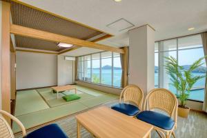 a dining room with a table and chairs and windows at Ooedo Onsen Monogatari Premium Toba Saichoraku in Toba