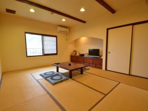 a living room with a table and a tv at umashiyado ryoutei minoshima in Kaino