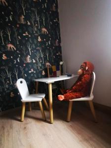a doll sitting in a chair next to a table at Ferienwohnung Alpakahof in Kleinreinsdorf