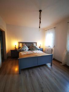 a bedroom with a bed with two lamps and a window at Ferienwohnung Alpakahof in Kleinreinsdorf