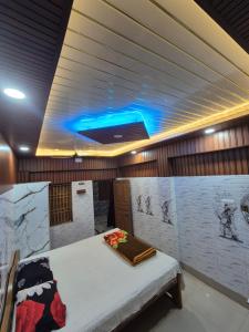a room with a bed and a blue light at New suvam lodge & hotel in mayapur