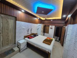 a room with a bed and a blue light at New suvam lodge & hotel in mayapur