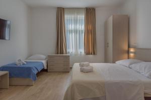 a bedroom with two beds and a dresser at Mobile Homes Camping Biograd in Biograd na Moru