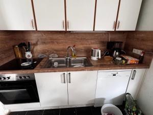 a kitchen with white cabinets and a sink at Bauernhof Privatzimmer Free WiFi Gemeinschaftsbad in Hausbreitenbach +8 photos