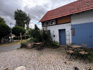 a building with a blue door and a table and chairs at Bauernhof Privatzimmer Free WiFi Gemeinschaftsbad in Hausbreitenbach