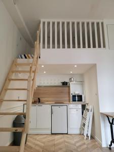 a kitchen with a loft bed and a kitchen with white cabinets at RUFFEC 14 1D in Ruffec
