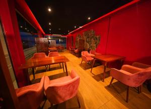 a restaurant with red walls and tables and chairs at Ramadia Ran Mal Holiday Resort in Moratuwa