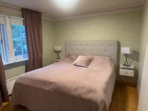 a bedroom with a bed with two lamps and a window at Privat strandvilla i vackra Geta in Geta