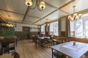 a dining room with tables and chairs and windows at Landgasthaus Grüner Baum in Simonswald