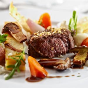 a plate of food with a piece of meat and vegetables at The Hill Guesthouse in Fludir