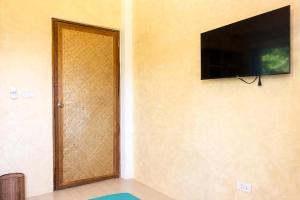 a room with a door with a television on the wall at Kalija in General Luna