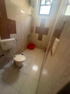 a bathroom with a toilet and a cross on the wall at Hotel JMR in Sohāna