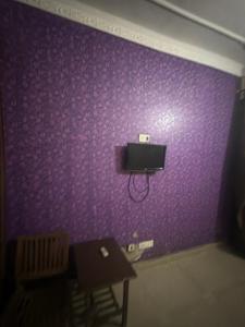 a purple wall with a tv on top of it at Hotel JMR in Sohāna