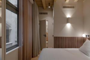 a bedroom with a bed and a window at Académie Hôtel Lyon in Lyon +28 photos