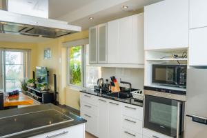 a kitchen with white cabinets and a black counter top at Tankini Beachfront Villa in Ban Khlong Son +81 photos