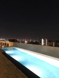 a swimming pool on the roof of a building at night at Cozy Studio in Nairobi's Prime Location in Nairobi