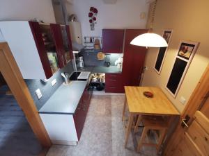 a kitchen with purple cabinets and a wooden table at Grenzstübchen in Hötensleben +15 photos