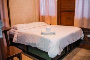 a white candle sitting on top of a bed at Alun Hostel in San Felipe