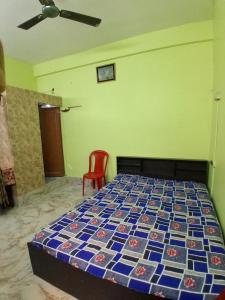 a bedroom with a bed and a red chair at Comfort Studio Type Appartment - Kolkata in Nager Bazaar