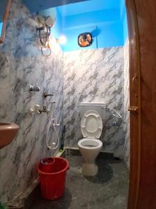 a bathroom with a toilet and a shower and a bucket at Comfort Studio Type Appartment - Kolkata in Nager Bazaar