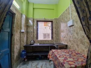 a bathroom with a sink and a bed in it at Comfort Studio Type Appartment - Kolkata in Nager Bazaar